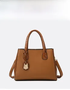 Detail of caramel tote bag with lychee grain leather and crocodile embossed handles