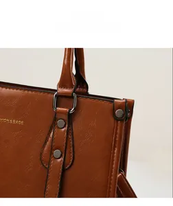 Détail du sac à main en cuir grainé caramel avec anneaux et rivets en métal foncé