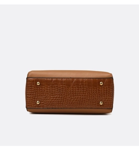 Detailed bottom view of brown handbag featuring crocodile pattern and gold protective feet