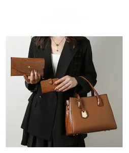 Three-piece brown faux leather handbag set with crocodile pattern and metal pendant