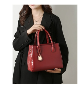 Detail of red tote bag featuring smooth faux leather and crocodile pattern texture