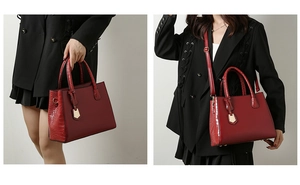 Detail of red crocodile texture tote bag with gold shield charm and adjustable strap