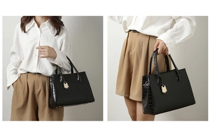 Detail of crocodile embossed leather and gold hardware on black shoulder bag