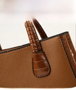 Close-up of caramel brown tote bag featuring contrast of litchi and crocodile leather texture