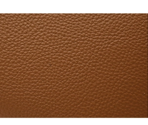 Close-up of caramel brown leather handbag with luxury crocodile embossed texture details