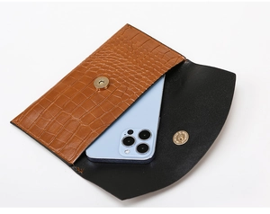 Detail of brown crocodile pattern envelope bag showing interior storage for a smartphone