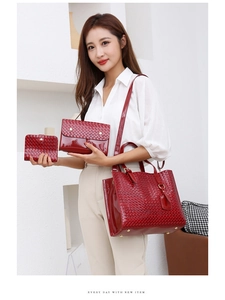 Close-up of red glossy woven texture handbag set with tote, clutch and wallet details
