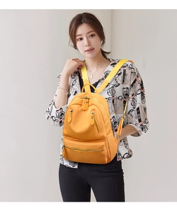 Détail du sac à dos en nylon jaune avec plusieurs zips et bretelles réglables