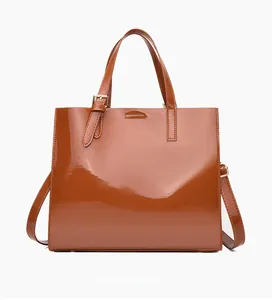 Rear view detail of brown patent leather tote bag with detachable shoulder strap and high gloss