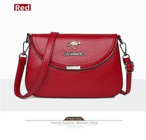 Detail of red pebbled leather crossbody bag with kangaroo logo and adjustable strap
