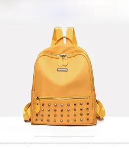 Front view of yellow backpack with stud rivets and double zipper compartments