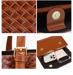 Detail view of woven leather texture, magnetic buckle, and interior capacity of the tote