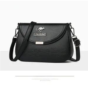 Detailed view of black litchi pattern leather crossbody bag with kangaroo metal logo