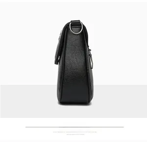 Side view of black crossbody bag showing textured pebble leather and silver metal rings