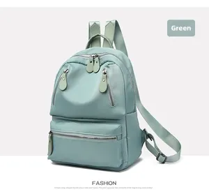 Détail du sac à dos en nylon vert menthe montrant plusieurs fermetures éclair et texture