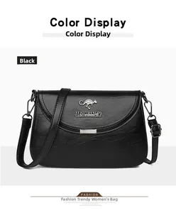 Detail view of black cross-body bag with pebble grain texture and metal kangaroo logo