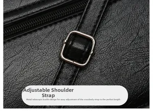 Detail of adjustable metal buckle, shoulder strap and back zipper on black leather bag