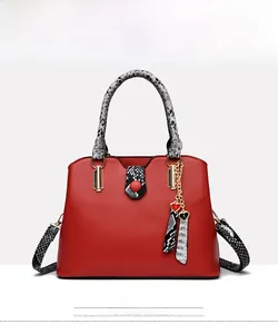 Front view of red faux leather handbag with snakeskin pattern straps and heart charms