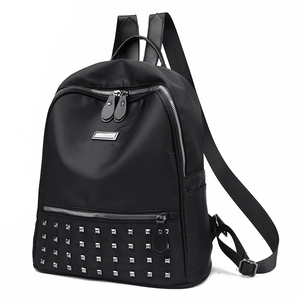 Fashionable black leather backpack with silver rivets and zippers on a clean white background