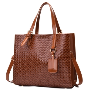 Brown woven faux leather tote bag with top handles and adjustable shoulder strap