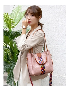 Pink crocodile-embossed tote bag with colorful ethnic style webbing and brown handles