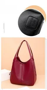 Close-up of burgundy lychee grain leather tote bag with embossed logo and stitching details