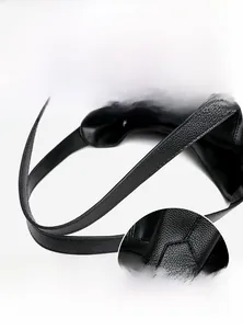 Detail of reinforced handle connection on black litchi grain leather tote bag