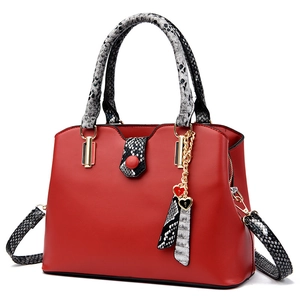 Red leather tote bag with snakeskin pattern details and heart charms in a 45-degree view