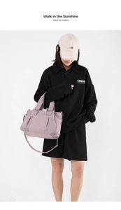 Close-up of light purple nylon handbag featuring a pleated design and wide shoulder strap