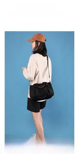 Black nylon tote bag with brown leather handles showing large capacity and shoulder carry