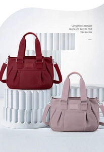 Detail of burgundy and dusty pink nylon tote bags with pleated texture and adjustable straps