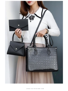 Detailed view of the three-piece handbag set featuring black crocodile pattern texture