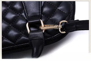 Detail der goldfarbenen Metallhaken und abnehmbarer Riemen an der gesteppten Tasche