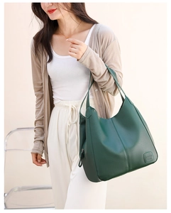 Close-up of the green leather tote bag featuring a pebbled texture and brand logo