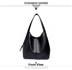 Close-up of black litchi pattern leather tote featuring fine stitching and square logo