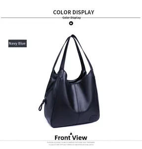 Detail of navy blue pebble leather tote bag featuring square embossed logo and side zipper