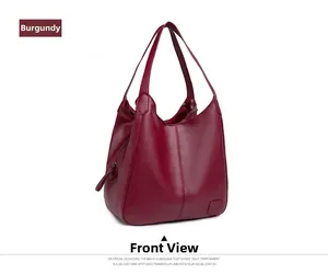 Close-up of burgundy pebbled leather tote bag with vertical stitching and brand patch