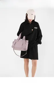 Detail of lavender nylon tote bag with pleated design and adjustable textile shoulder strap