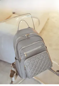 Detail of grey oxford backpack featuring quilted rhombus pattern and gold rivet accents