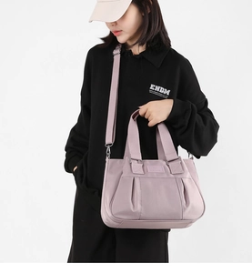 Detail of lavender nylon tote bag with pleated design and wide shoulder strap