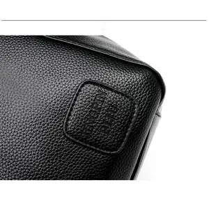 Close-up of black litchi grain leather texture and embossed JINGPIN PJH logo on tote bag
