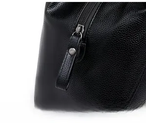 Detailed macro view of smooth metal zipper and pebbled leather texture on black tote