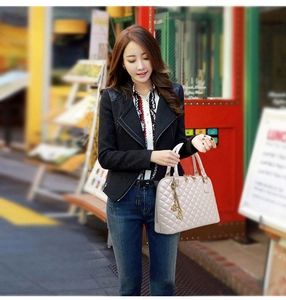 Beige gesteppte Handtasche mit Doppelgriffen und Metallanhänger in einem Street-Lifestyle-Set