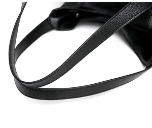 Close-up of soft lychee pattern leather handles with reinforced double stitching on black tote