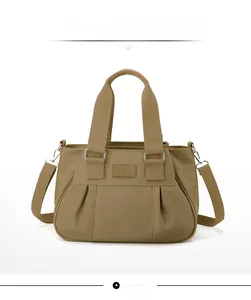 Front view of khaki nylon handbag featuring pleated design and adjustable strap