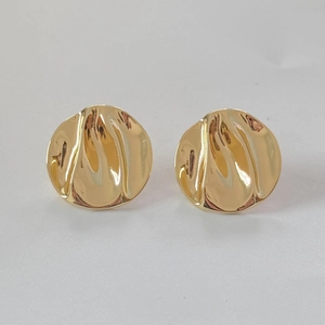 Detail of irregular hammered gold stud earrings with a unique molten lava texture