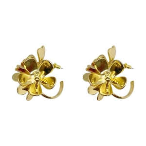 Macro view of gold flower earrings with curved petals and central decorative stamen details