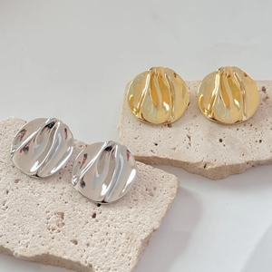 Irregular hammered metal earrings in gold and silver finish with wavy texture