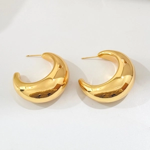 Close-up of high-polished gold crescent hoop earrings with a sleek minimalist design
