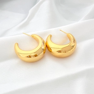 Detailed macro shot of golden chunky hoop earrings with a polished mirror finish